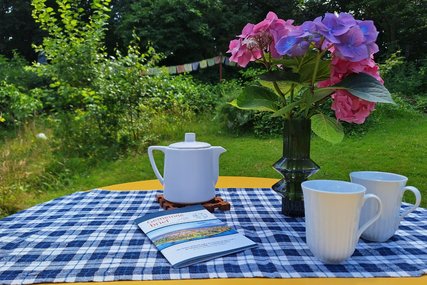 Sommerliche Gartenszene mit dem neuen Gemeindebrief - Copyright: Pastor Arne Kutsche